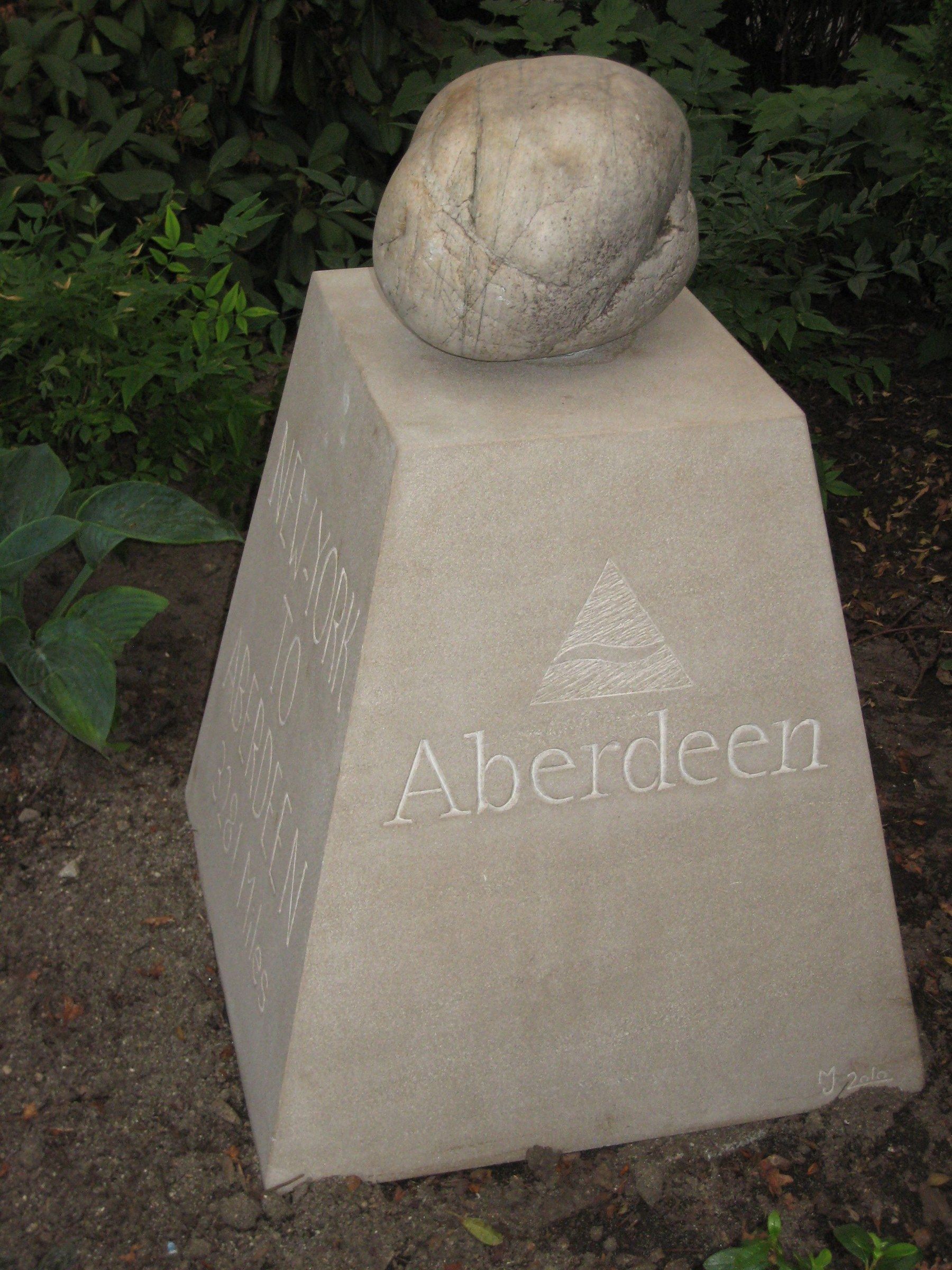 La face de la borne sculptée d'un emblème triangulaire au-dessus du mot « Aberdeen ».