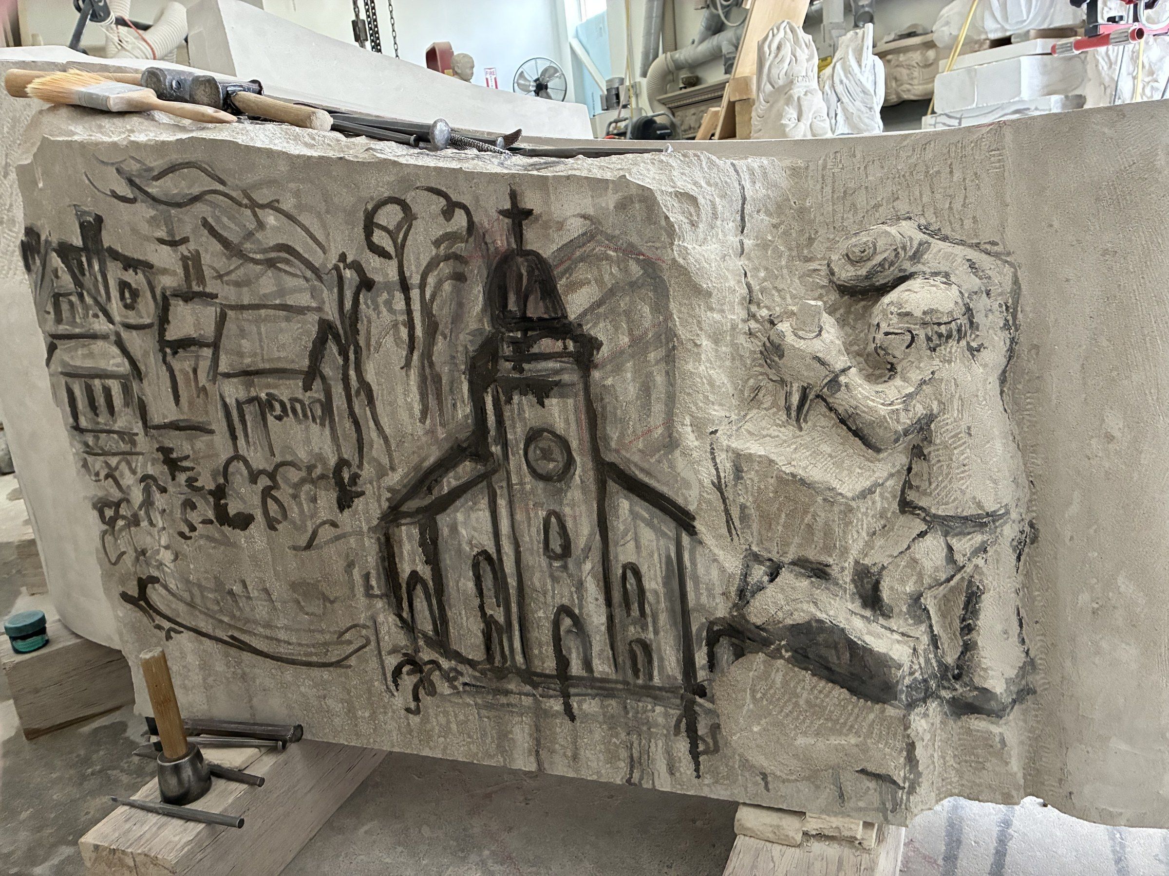 Detailed marker drawing on the stone in late April 2026 — the church, the house and the bearded figure of the sculptor sketched directly onto the surface before the chisel begins.