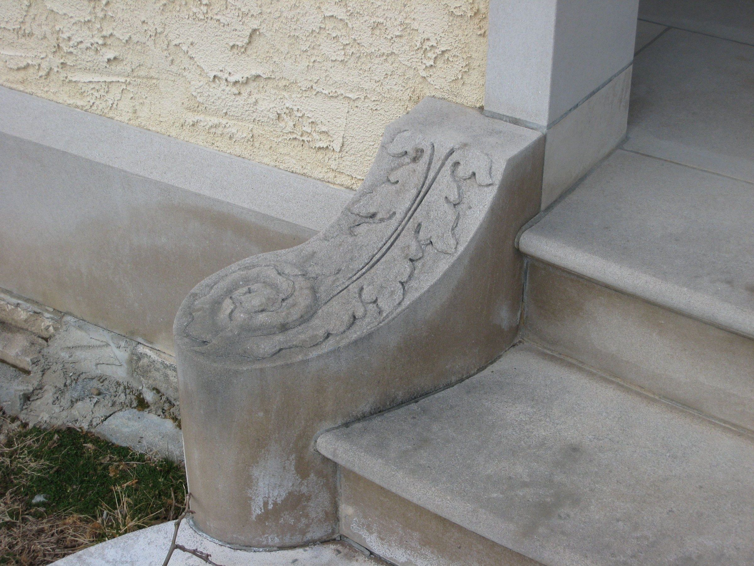 Close-up of one volute: a spiral scroll with a leaf running along its curve.